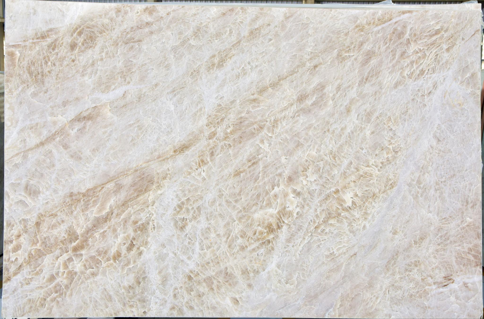 Naica — soft ivory-beige base with delicate, light feathered movement.